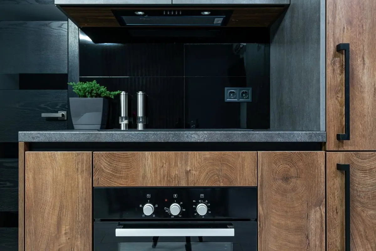 Cocina moderna con gabinetes de madera y grifería negra